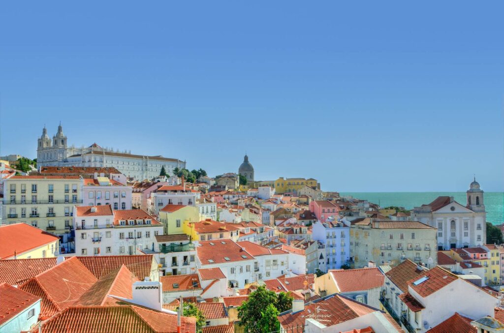 Casas coloridas sob um céu azul brilhante. Photo: Skitterphoto